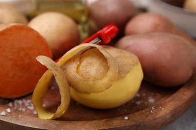 Photo of Different types of fresh potatoes wooden board, closeup