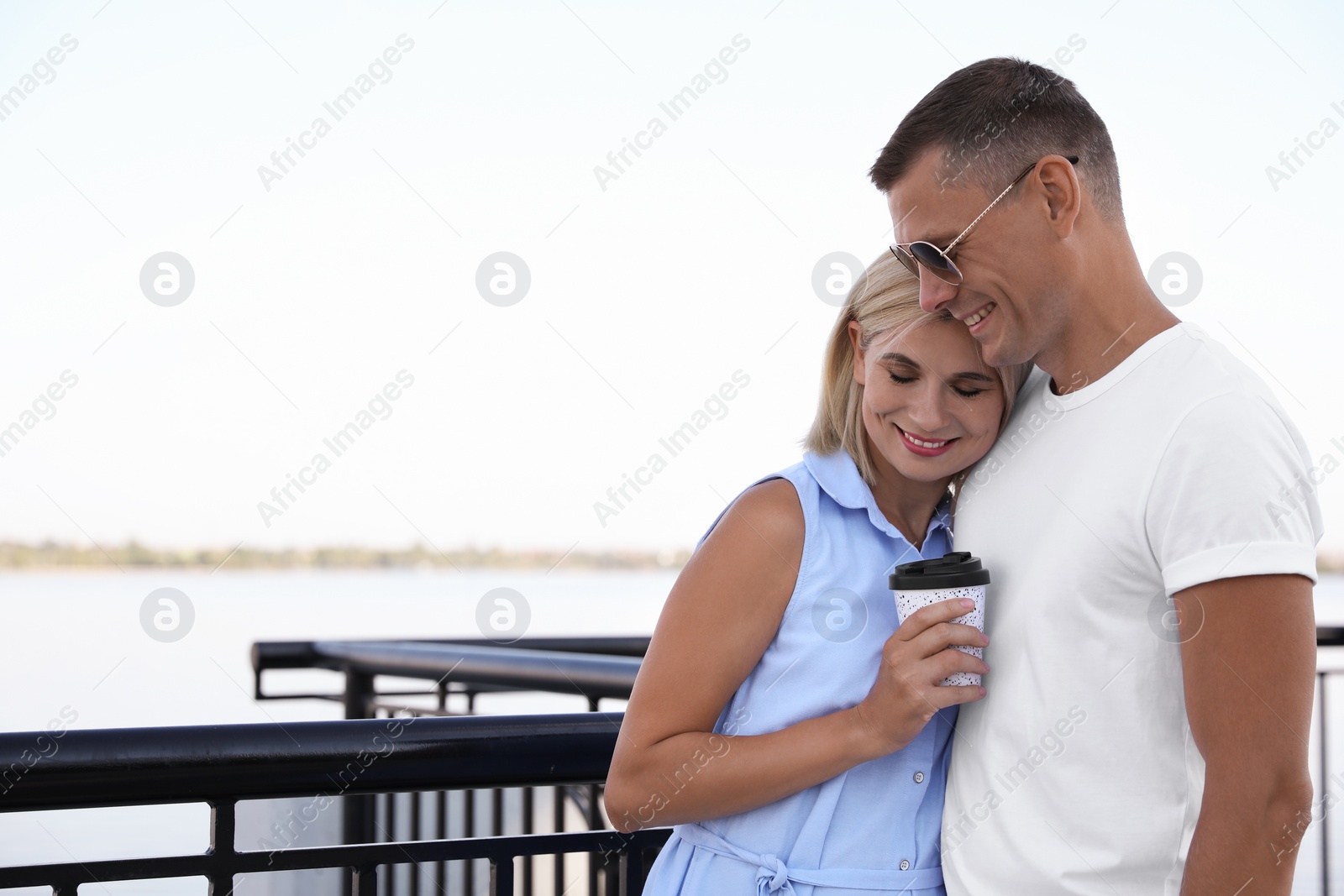 Photo of Happy couple with drink on city waterfront