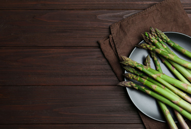 Fresh raw asparagus on wooden table, flat lay. Space for text