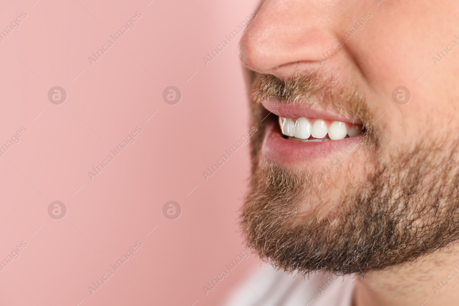 Photo of Young man with healthy teeth on color background, closeup. Space for text