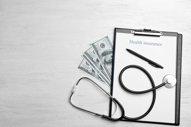 Photo of Flat lay composition with health insurance form and stethoscope on white wooden surface. Space for text