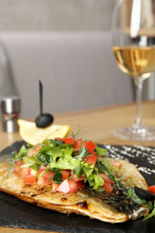 Photo of Delicious grilled fish with vegetables served on wooden table. Space for text