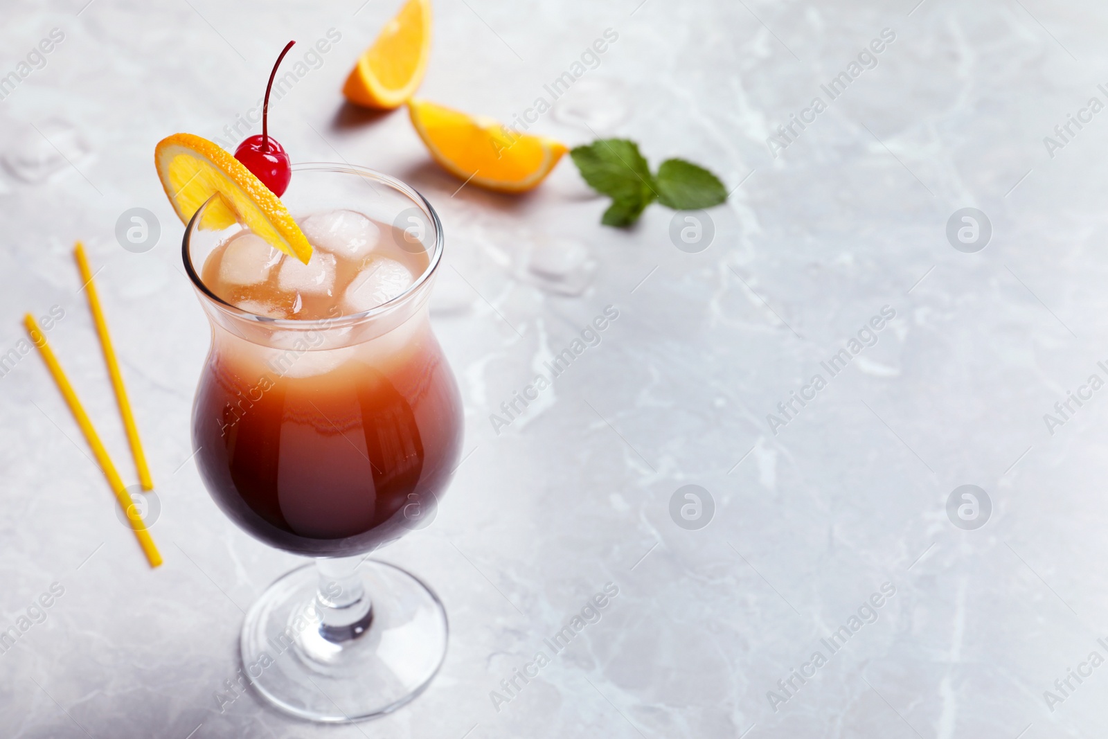 Photo of Glass of tasty refreshing cocktail on marble table. Space for text