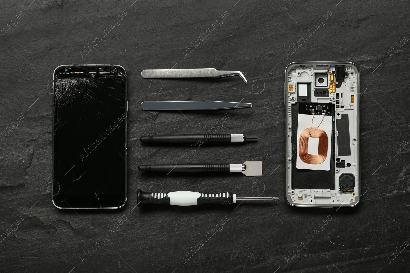 Photo of Damaged smartphone and repair tools on black background, flat lay