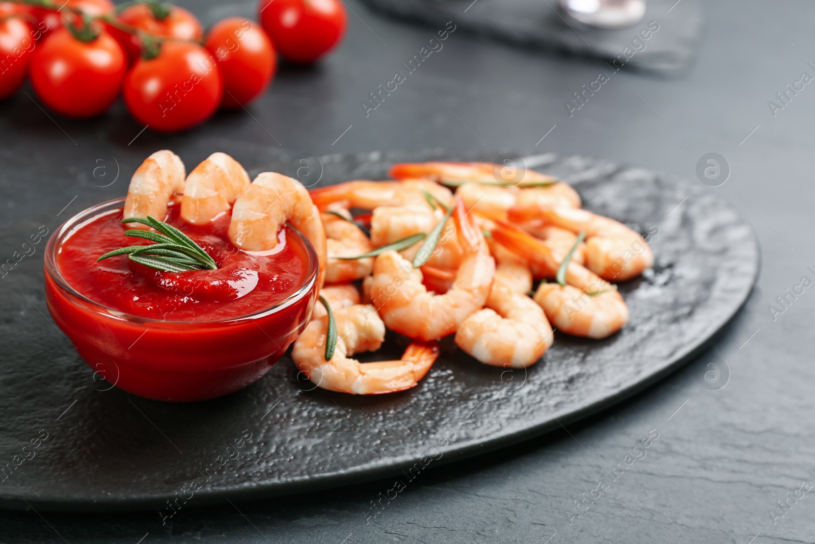 Photo of Delicious shrimp cocktail with tomato sauce served on black table