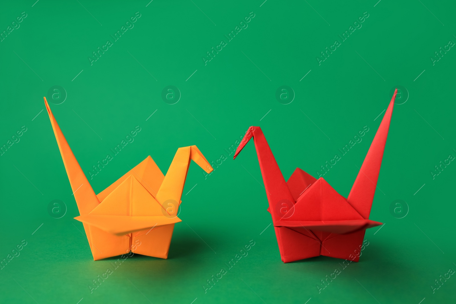 Photo of Colorful paper origami cranes on green background