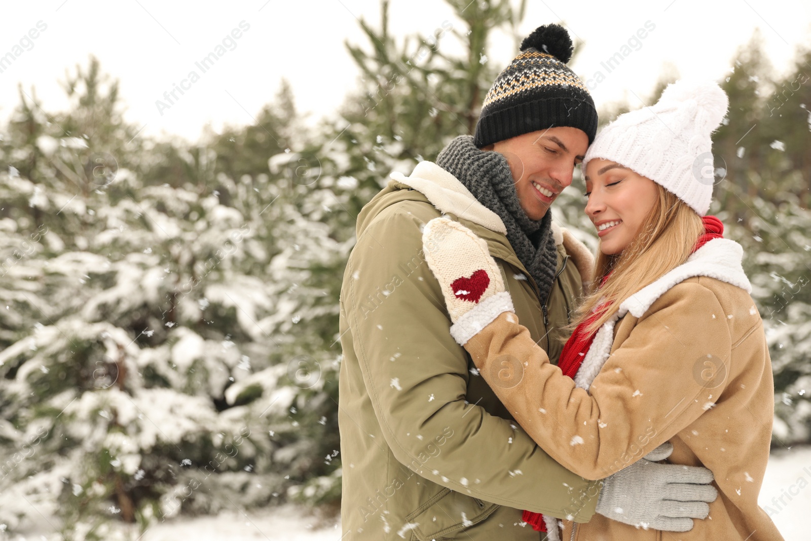 Photo of Beautiful happy couple in snowy forest on winter day