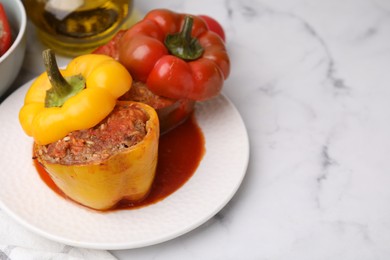 Photo of Delicious stuffed bell peppers served on white marble table. Space for text