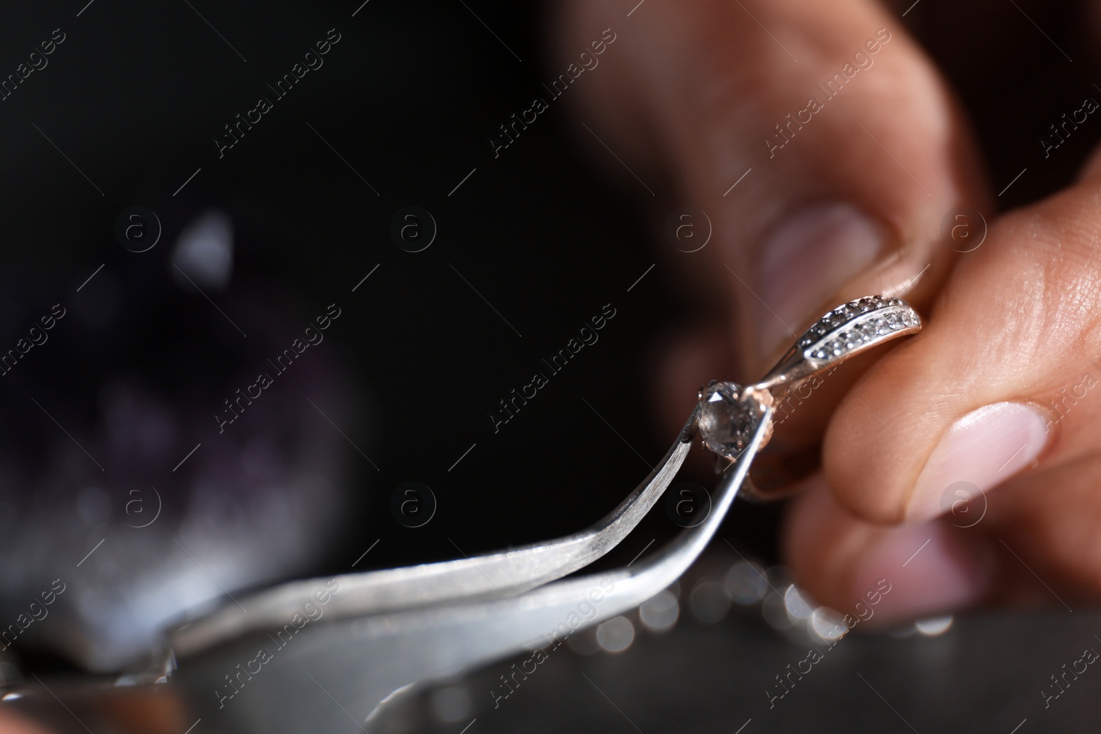 Photo of Male jeweler examining diamond ring in workshop, closeup view