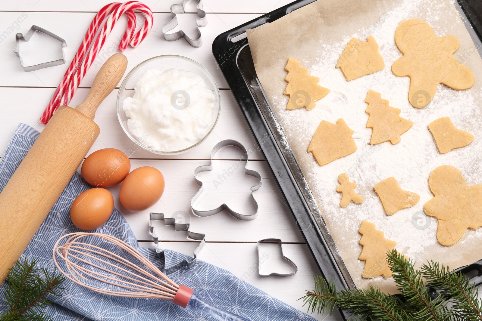 Photo of Making Christmas cookies. Flat lay composition with raw dough and ingredients on white wooden table