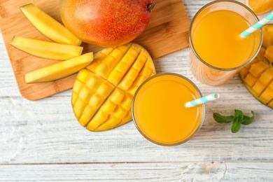 Tasty mango drink and fresh fruits on wooden table, top view