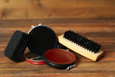 Composition with shoe care accessories on wooden table, closeup