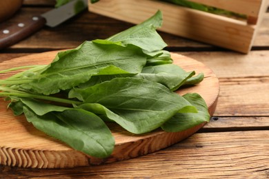 Photo of Fresh green sorrel leaves on wooden table, closeup