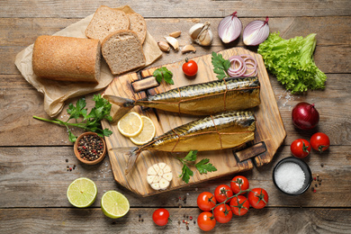 Photo of Flat lay composition with tasty smoked fish on wooden table