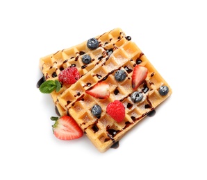 Photo of Yummy waffles with berries and chocolate syrup on white background, top view