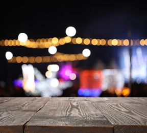 Empty wooden surface against blurred lights. Bokeh effect 