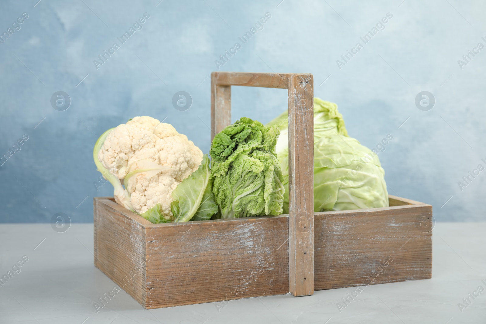 Photo of Basket with tasty cabbages on grey table