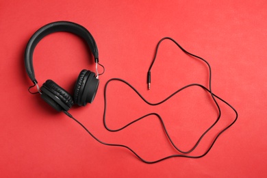 Photo of Stylish headphones on color background, top view