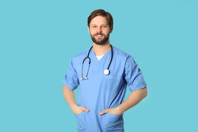 Photo of Happy doctor or medical assistant (male nurse) with stethoscope on turquoise background