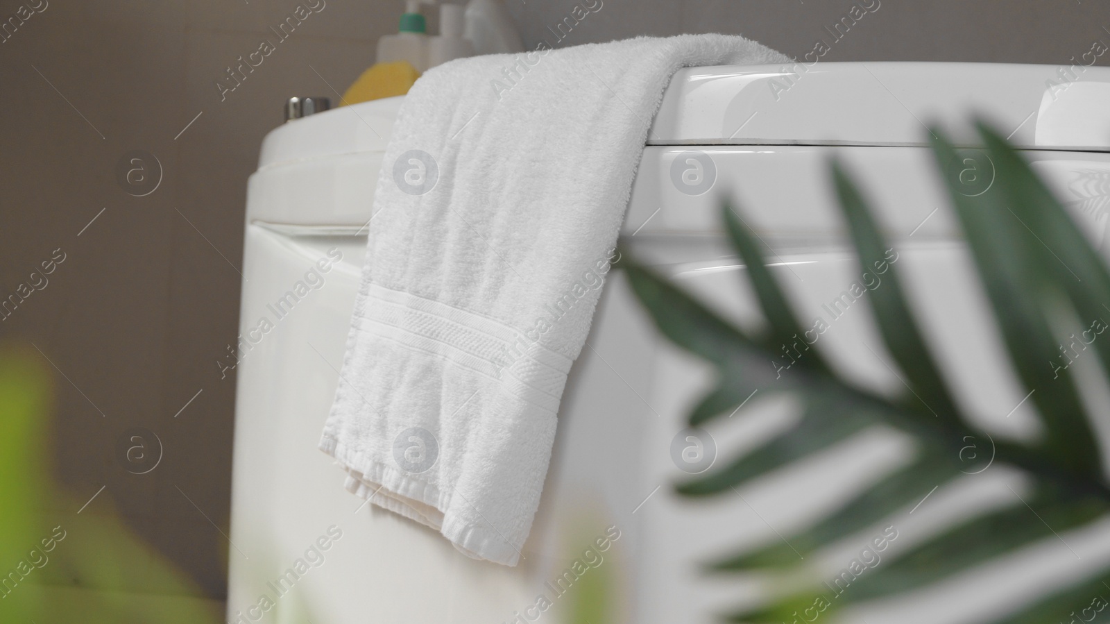 Photo of Soft fluffy towel hanging on bathtub indoors