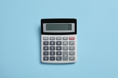 Photo of Calculator on light blue background, top view. Office stationery