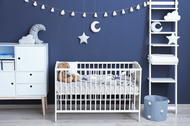 Stylish baby room interior with comfortable crib