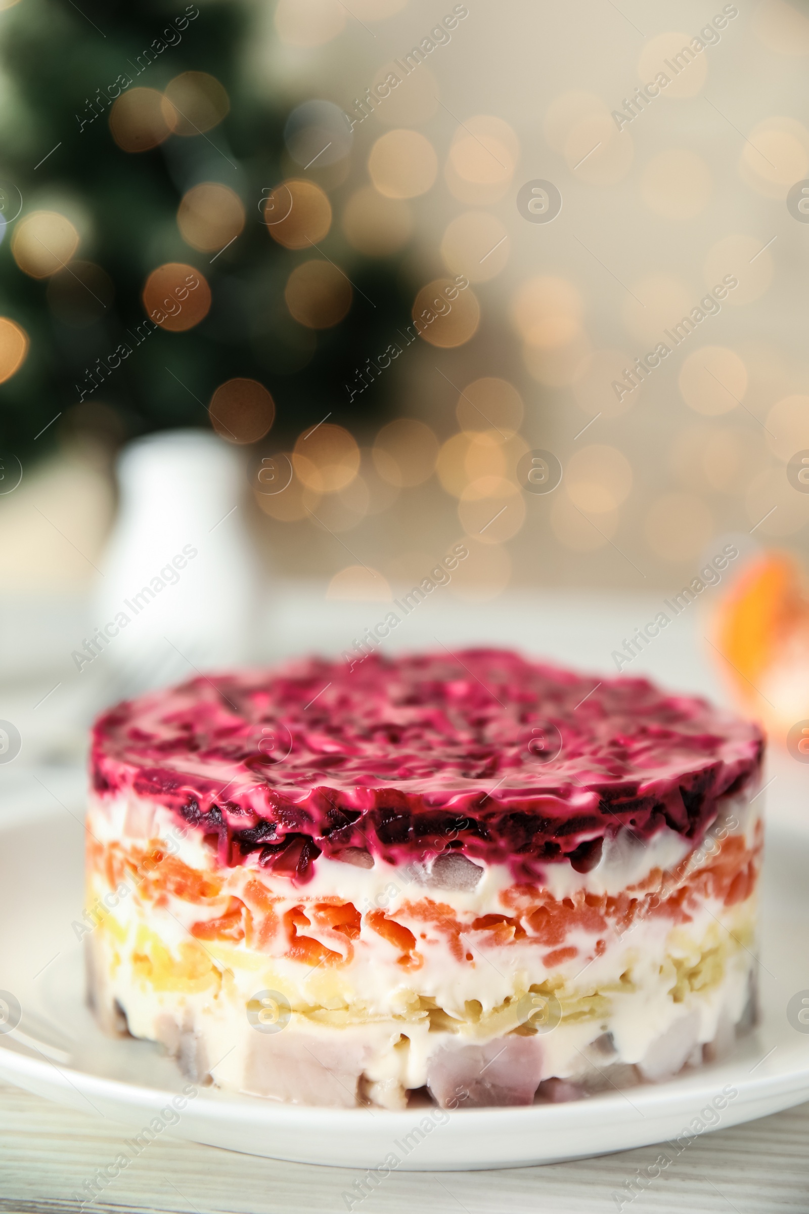 Photo of Herring under fur coat served on white wooden table, space for text. Traditional russian salad