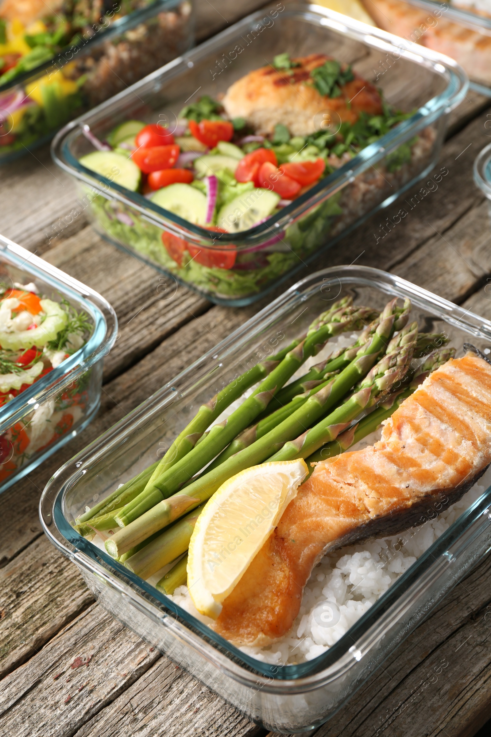 Photo of Healthy meal. Containers with different products on wooden table