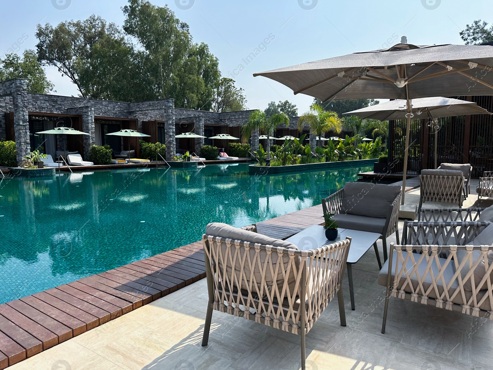 Photo of Outdoor furniture in recreation area near swimming pool at resort