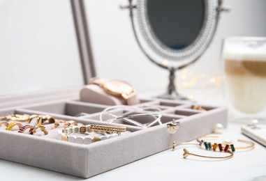 Photo of Elegant jewelry box with beautiful bijouterie on white table, closeup
