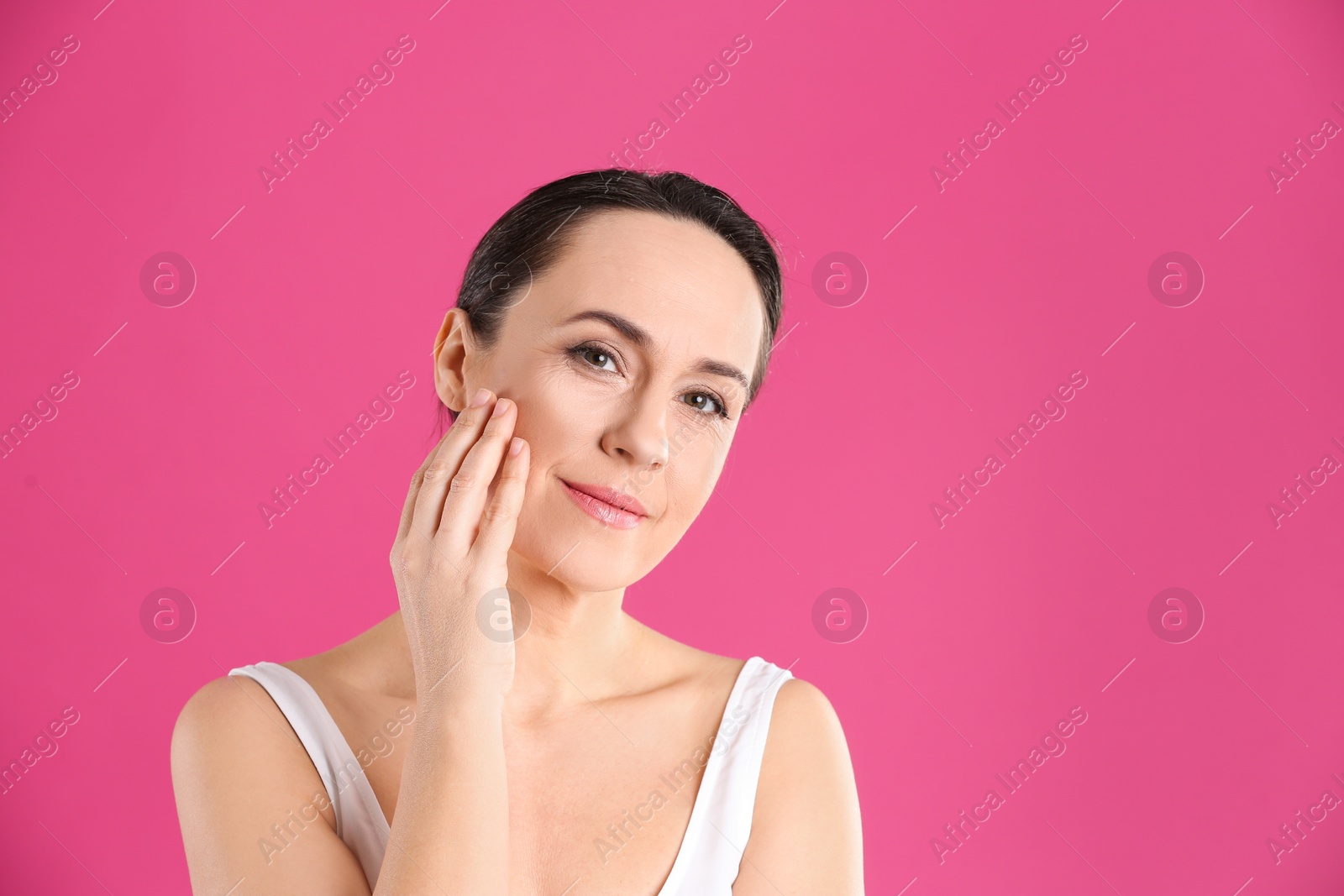 Photo of Portrait of beautiful mature woman on pink background. Space for text