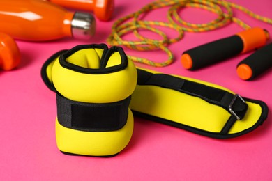 Photo of Yellow weighting agents and sport equipment on pink background