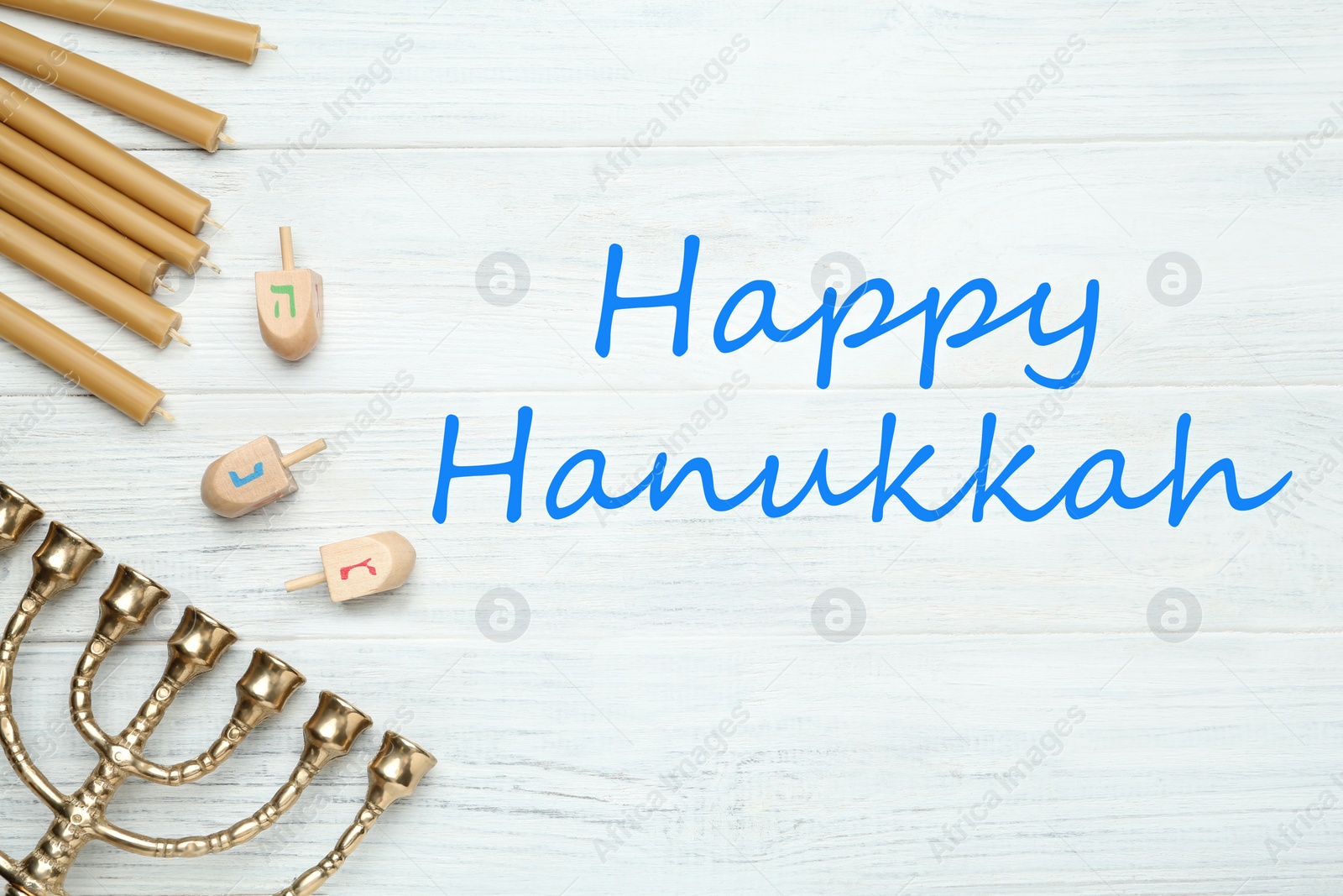 Image of Happy Hanukkah. Traditional menorah, candles and dreidels on white wooden table, flat lay 