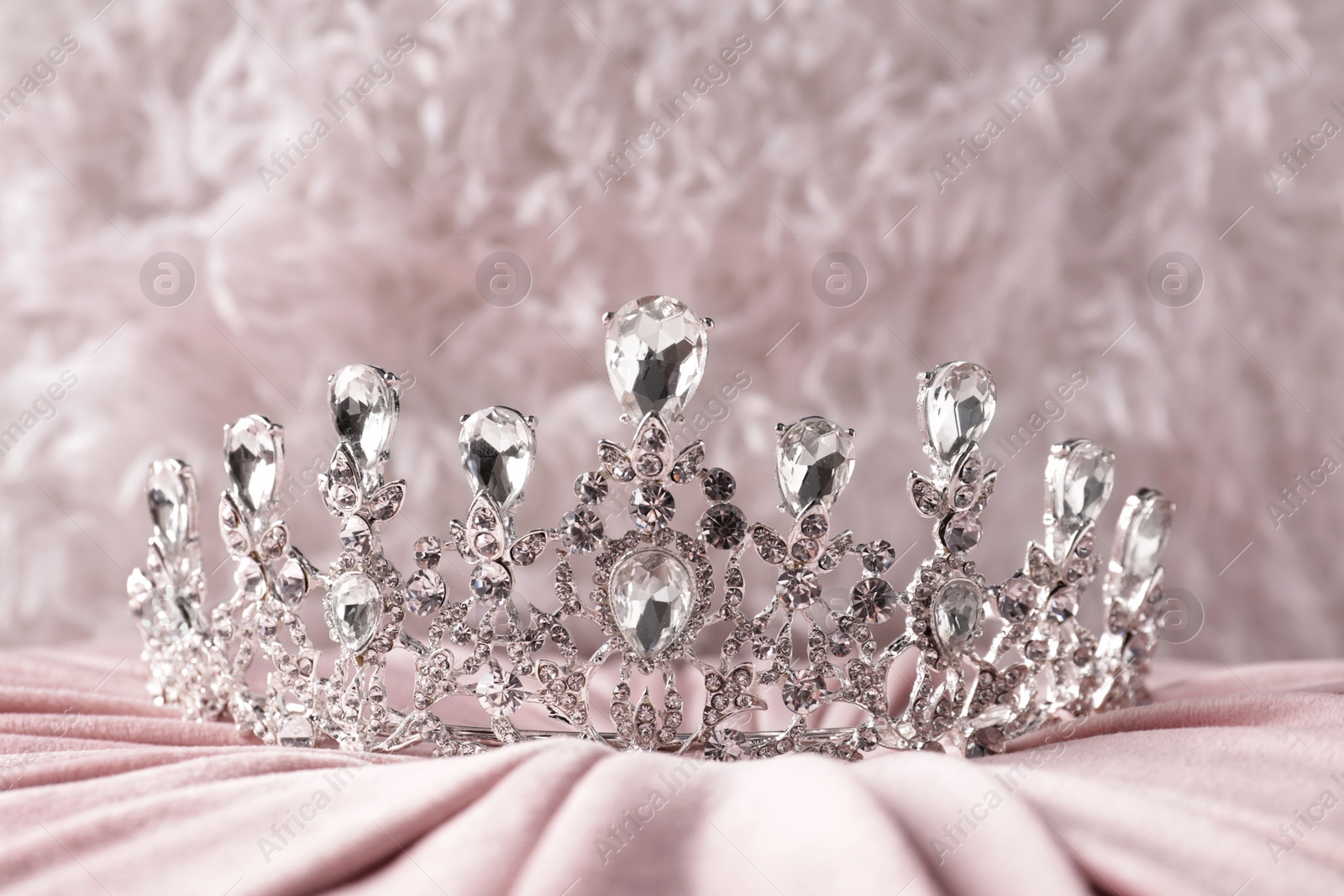 Photo of Beautiful silver tiara with diamonds on pink cloth