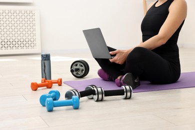 Online fitness trainer. Woman watching tutorial on laptop indoors, closeup