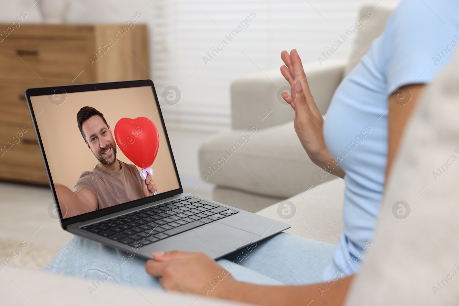 Image of Long distance love. Woman having video chat with her boyfriend via laptop at home, closeup