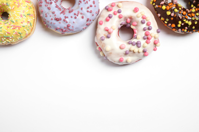 Photo of Delicious glazed donuts on white background, flat lay. Space for text