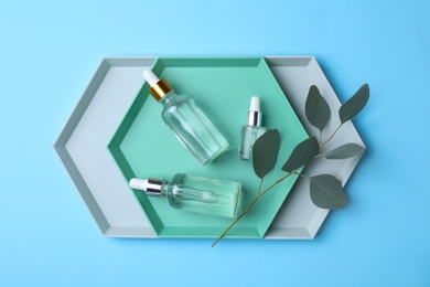 Flat lay composition with bottles of perfume on color background