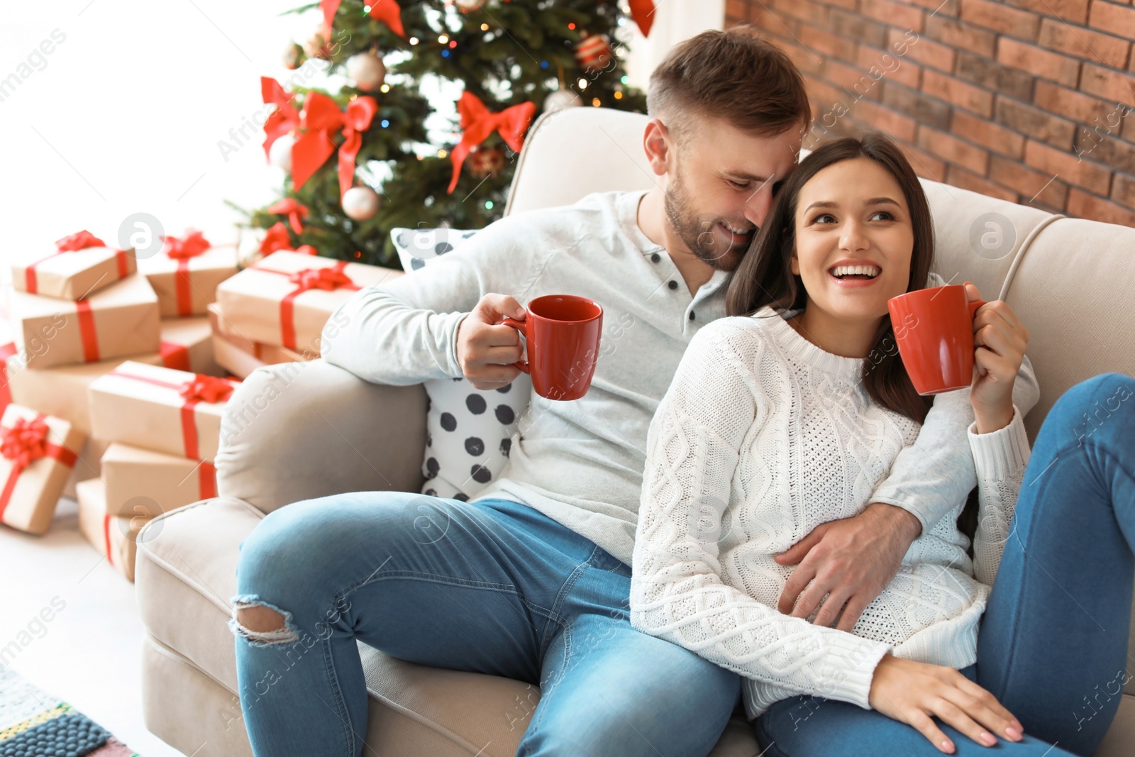 Photo of Happy young couple celebrating Christmas at home