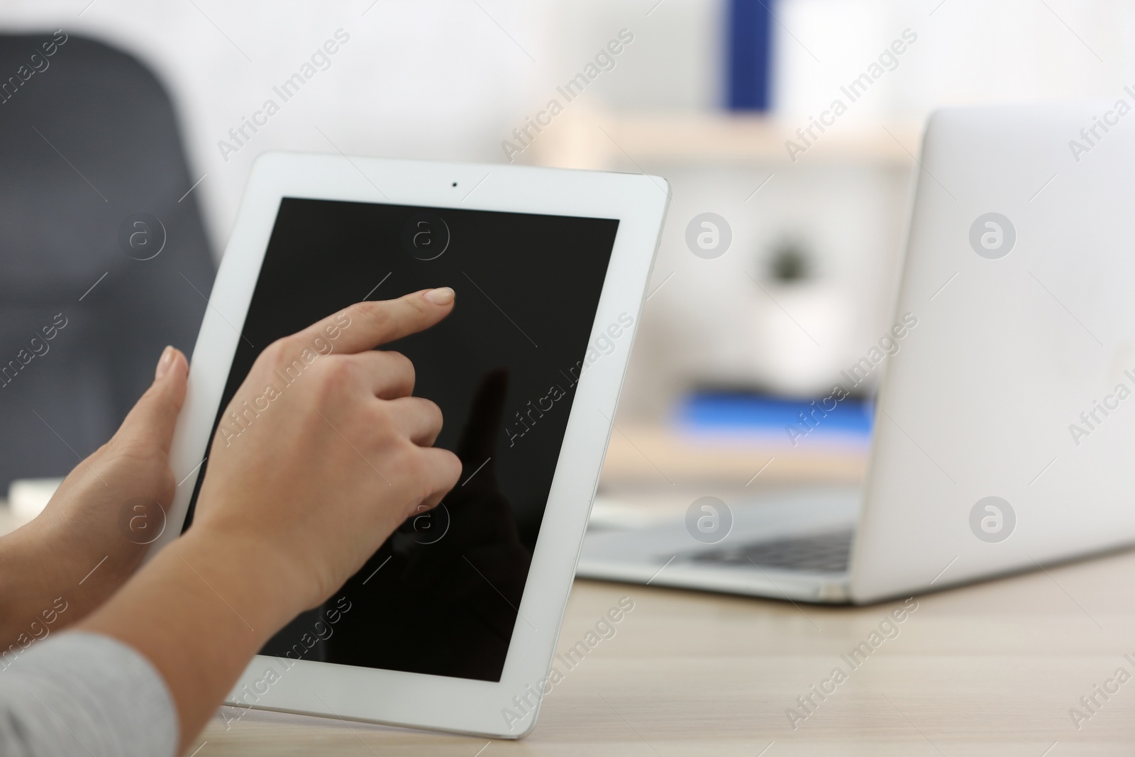 Photo of Young woman using new modern tablet in office, closeup. Space for text