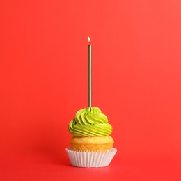 Birthday cupcake with candle on red background
