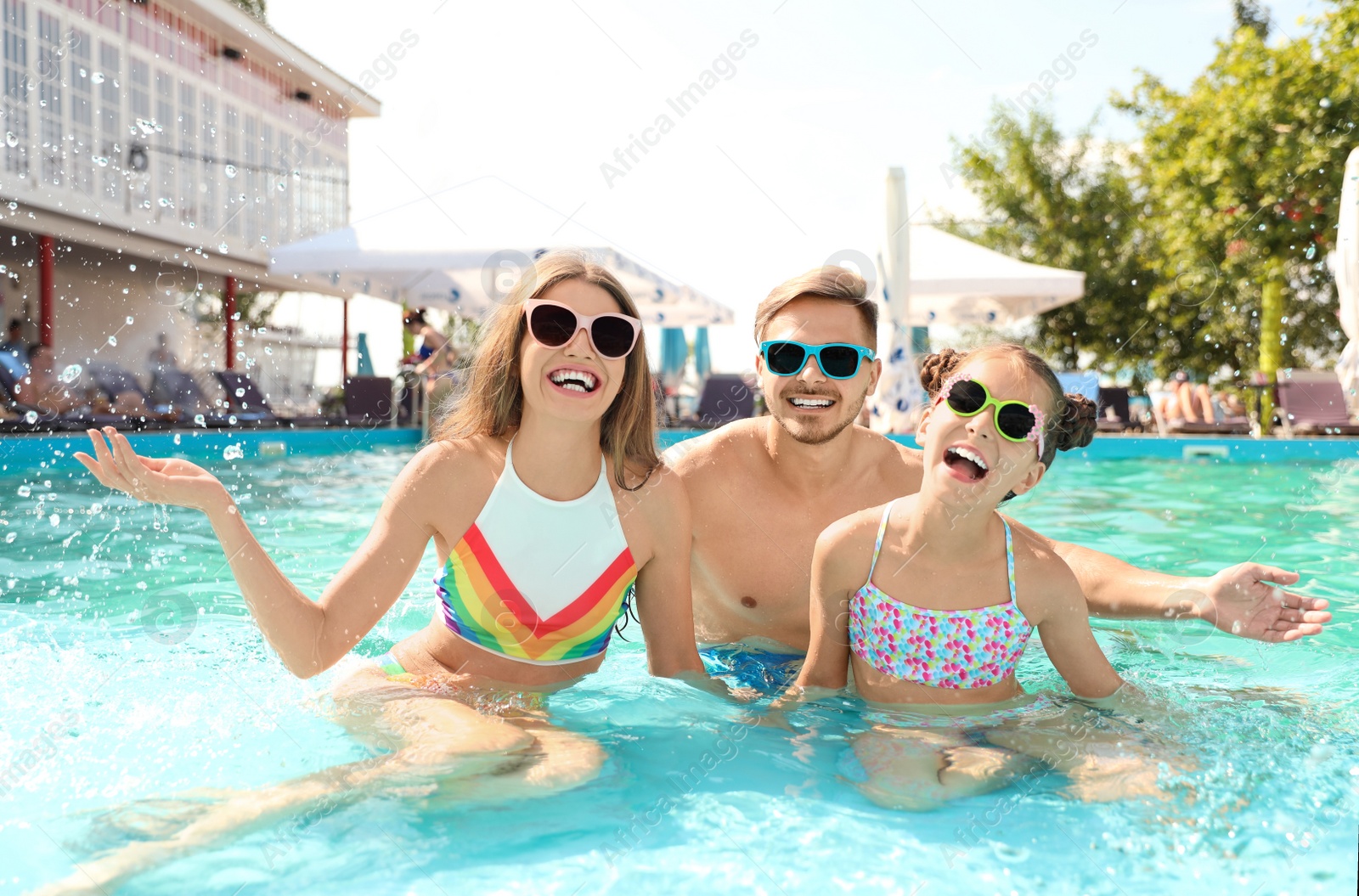 Photo of Happy family in pool on sunny day