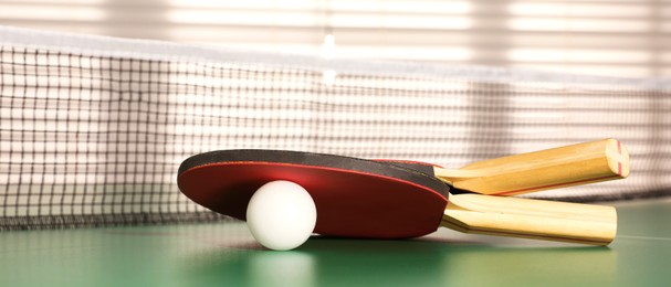 Image of Rackets and ball on ping pong table indoors. Banner design