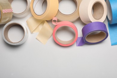 Photo of Many rolls of adhesive tape on light background. Space for text