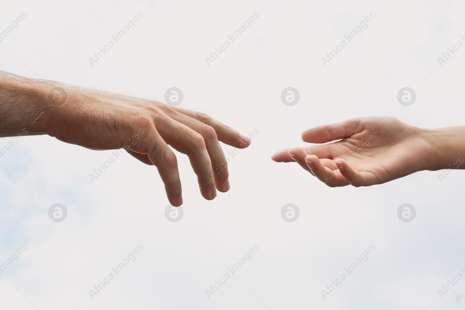 Photo of Man and woman giving each other hands on light background. Concept of support and help