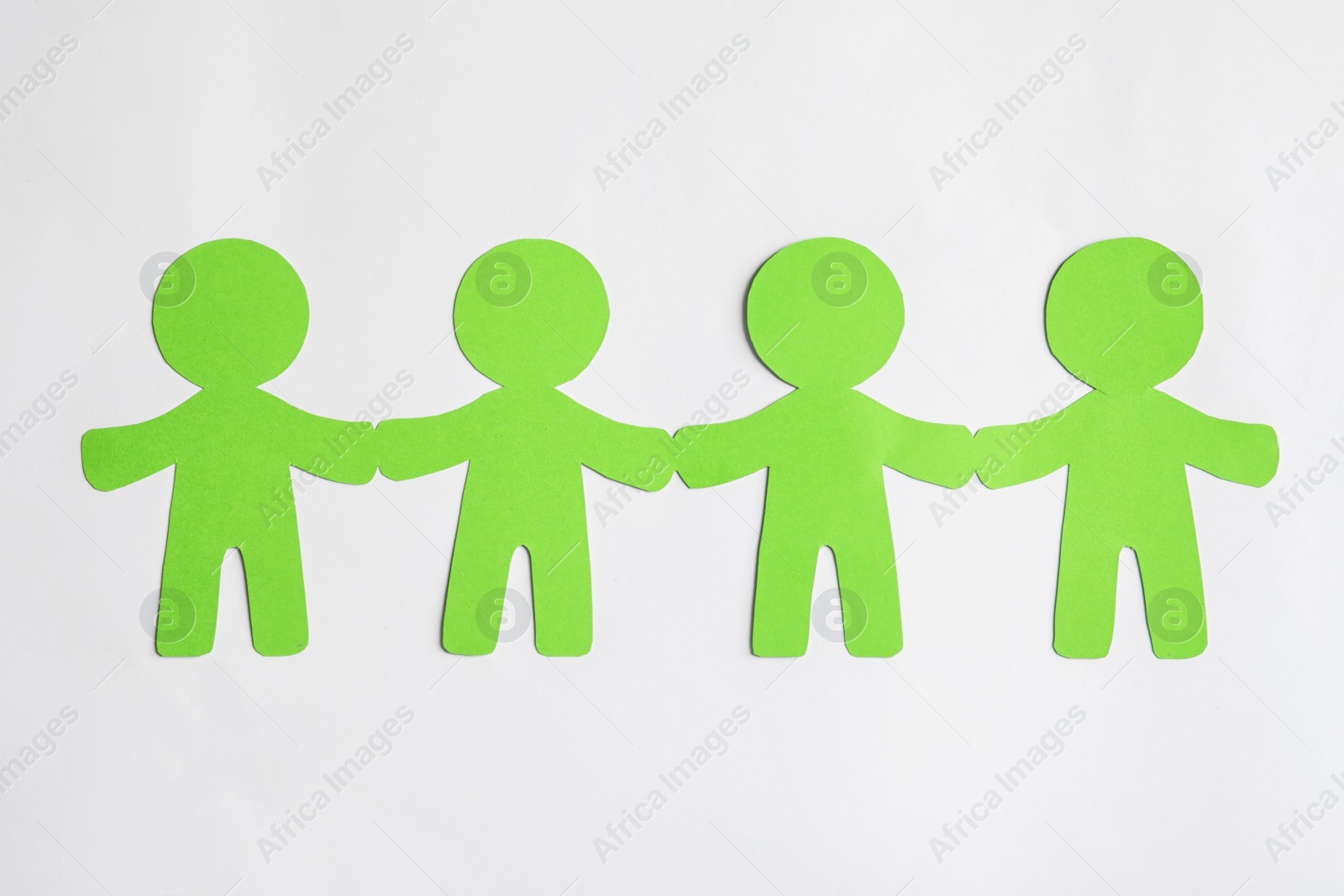 Photo of Paper people holding hands on light background. Unity concept