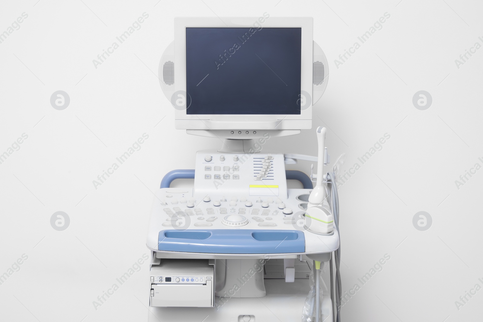 Photo of Ultrasound machine near white wall. Medical equipment