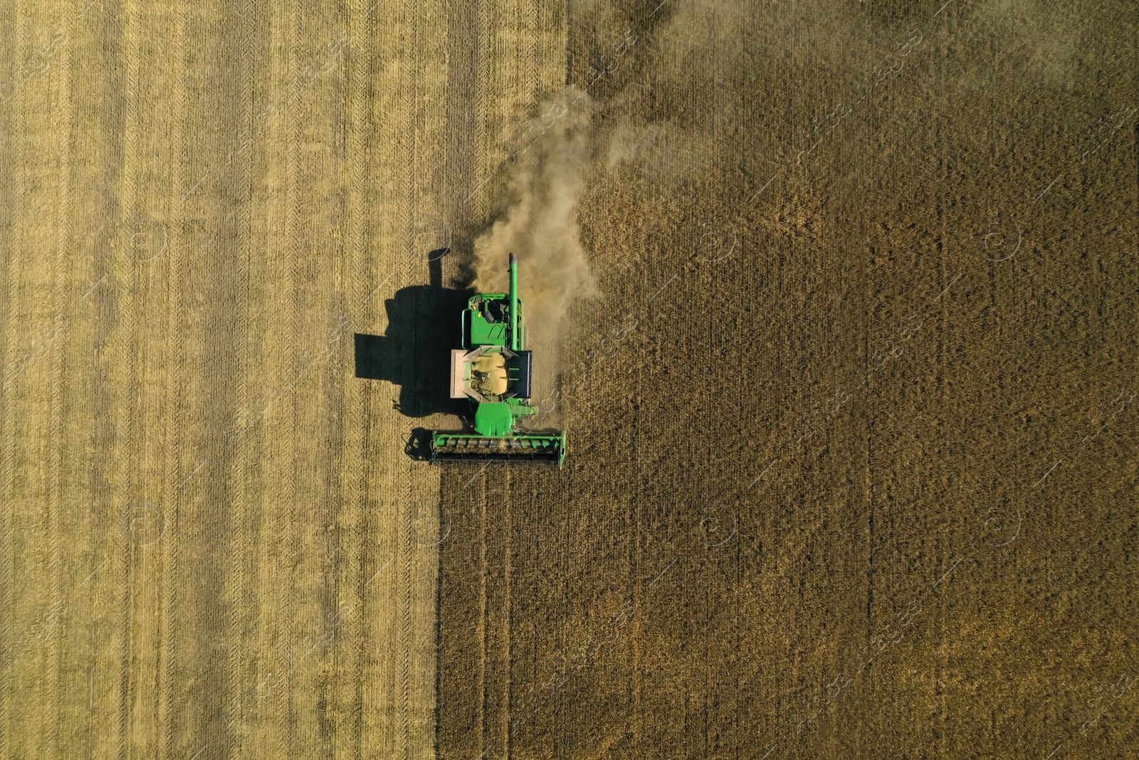 Photo of Beautiful aerial view of modern combine harvester working in field on sunny day. Agriculture industry