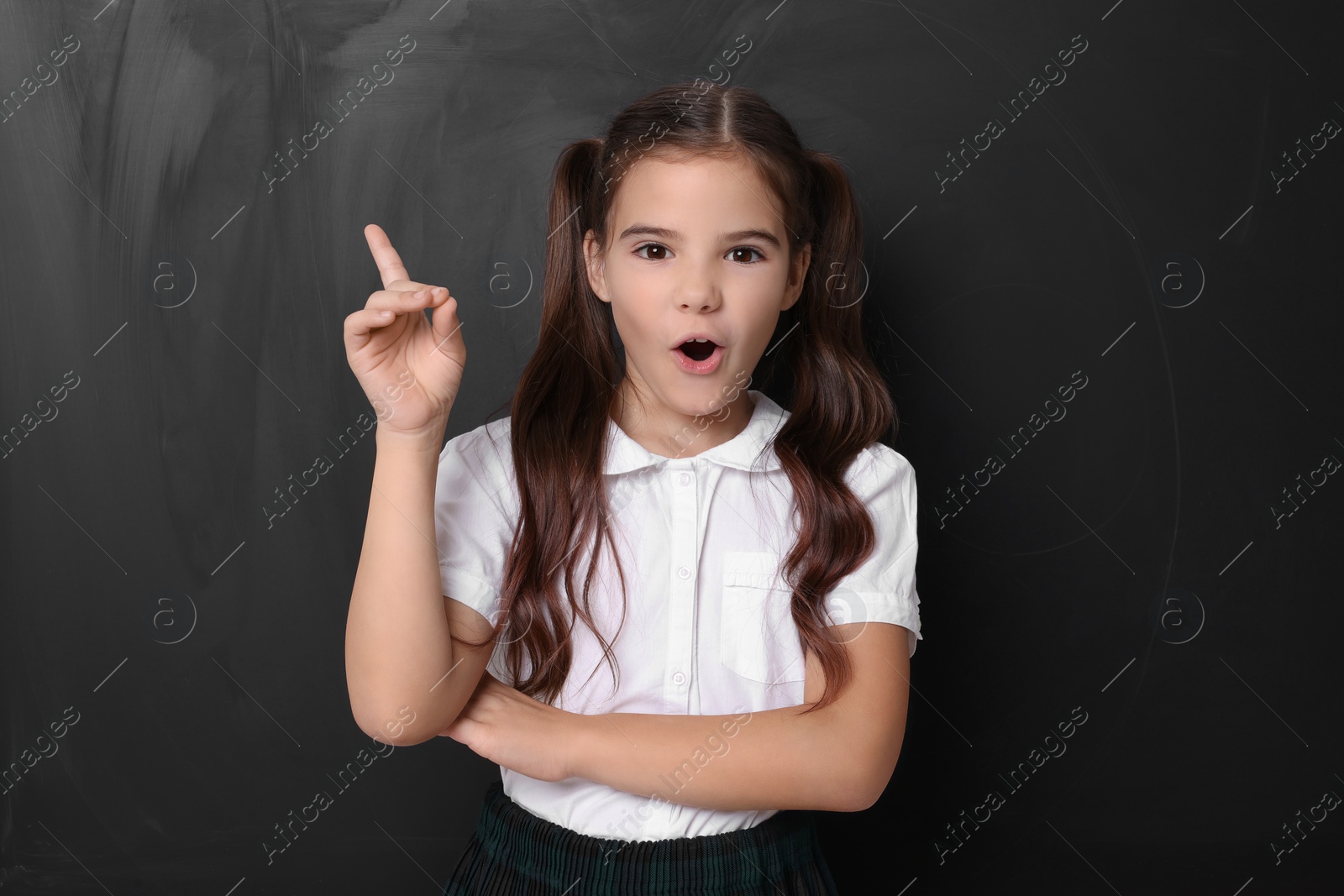 Photo of Back to school. Surprised girl near chalkboard