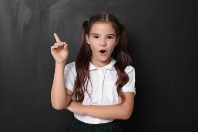 Photo of Back to school. Surprised girl near chalkboard